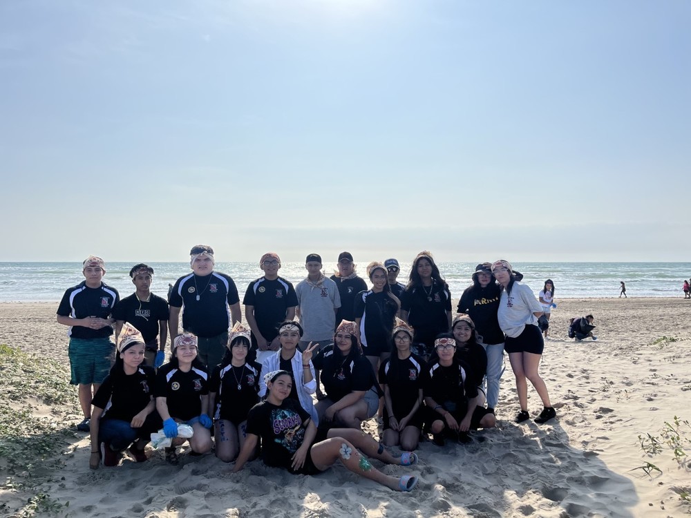 students posing at beach after cleaning up trash