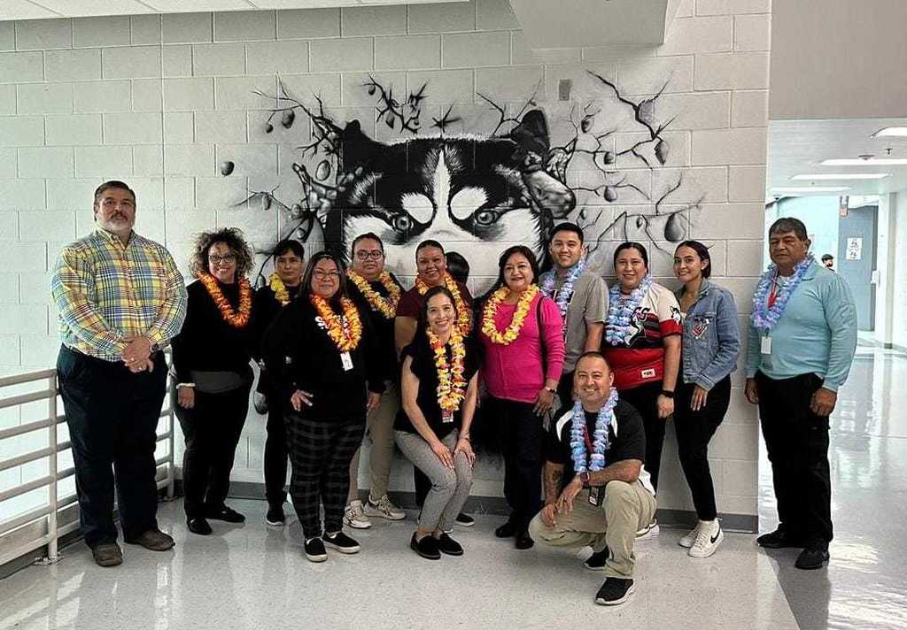 Paraprofessional staff posed with flowers on their necks