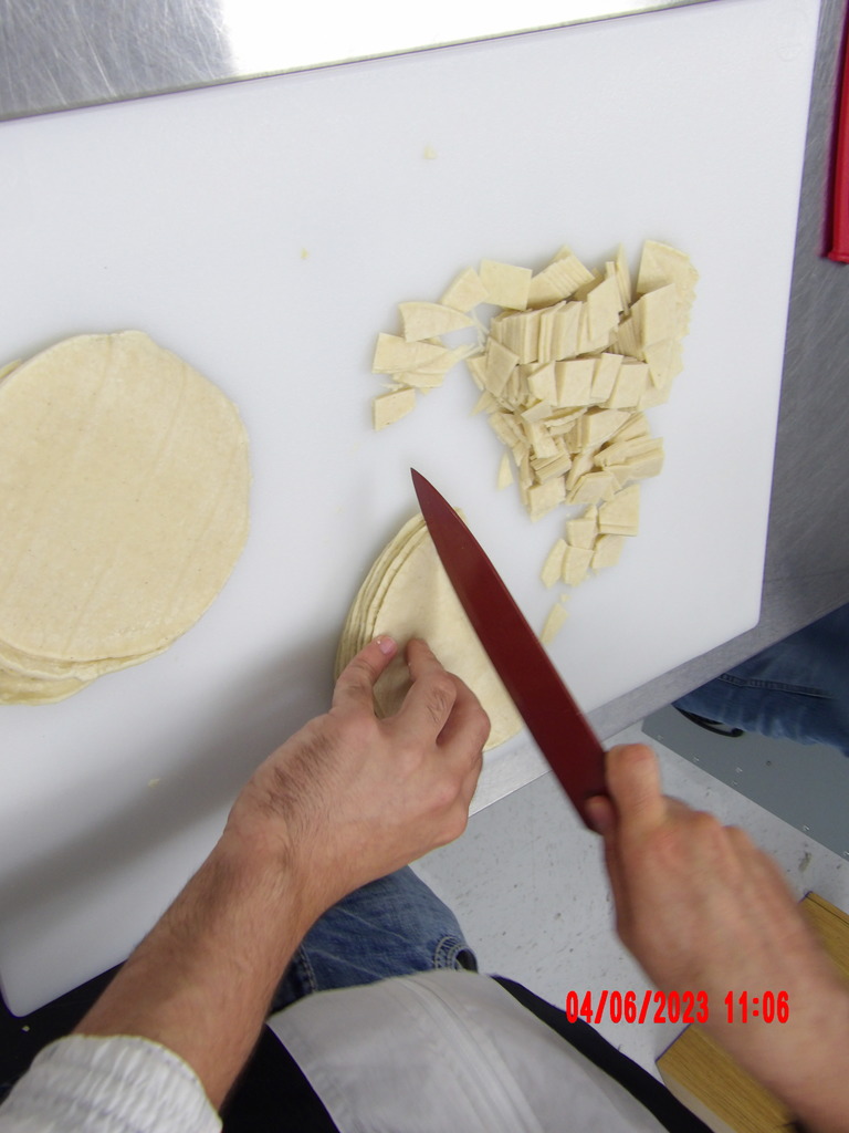 student chopping tortillas on cutting board