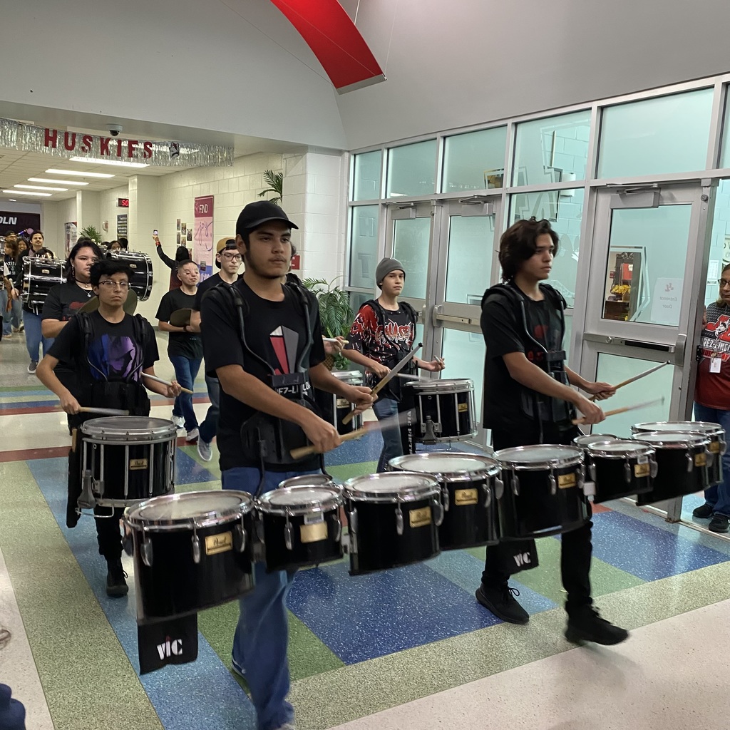 drumline playing and marching through school hall 